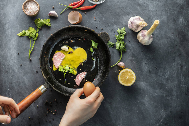 bacon ou carne cortada em fatias e folhas de ervas numa frigideira quente, ovos mexidos fogões
 - Foto, Imagem