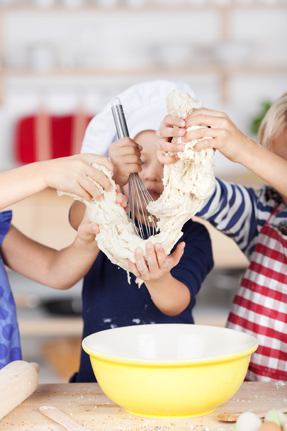 Girl Using Whisk On Dough While Siblings Holding It - Foto, immagini