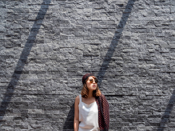 bela elegante hipster ásia mulher no moderno cinza tijolo w
 - Foto, Imagem