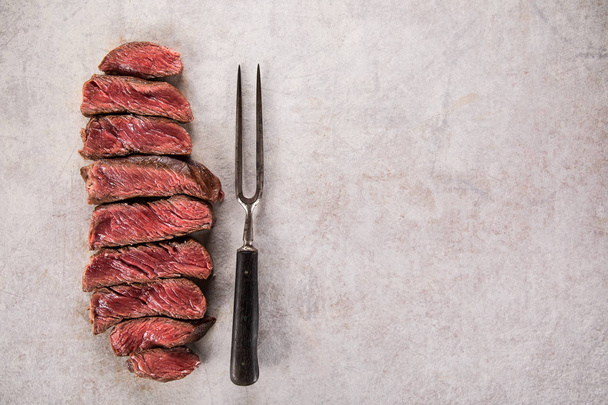 Grilled beef steak on black stone table. Top view. - Fotó, kép