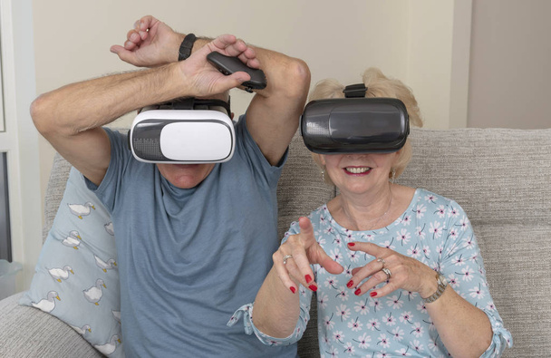 Portsmouth İngiltere, Mayıs 2019. Yaşlı çift sanal gerçeklik gözlüğü giyerek eğleniyor - Fotoğraf, Görsel