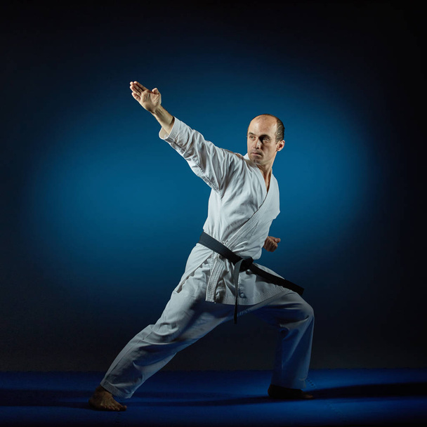 Actieve man voert formele Karate oefeningen uit - Foto, afbeelding