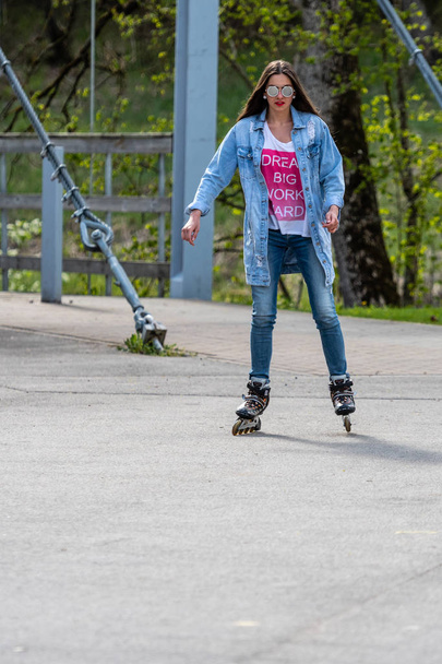 DOBELE, LATVIA, - MAY 7, 2019:  A young woman in sunglasses on roller skates. - Fotó, kép