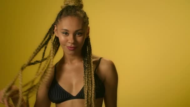 Afro amerykańska Kobieta dotyka dredy i pozowanie na kamerę - Materiał filmowy, wideo