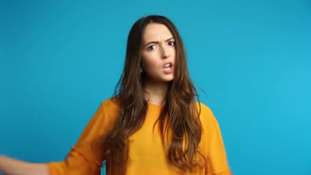Young angry woman says no standing isolated over blue background. negative emotion concept - Video