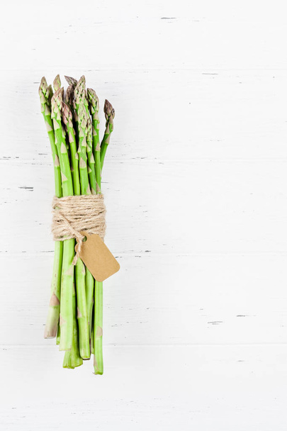 Fresh green asparagus on white wooden background - Foto, afbeelding