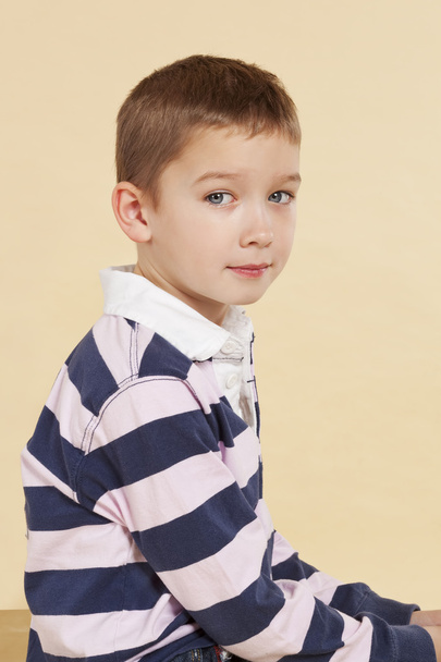 Young boy sitting and looking into camera isolated. - Photo, Image