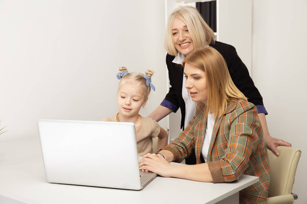 Bambino felice con nonna e madre che usano il computer portatile insieme
. - Foto, immagini