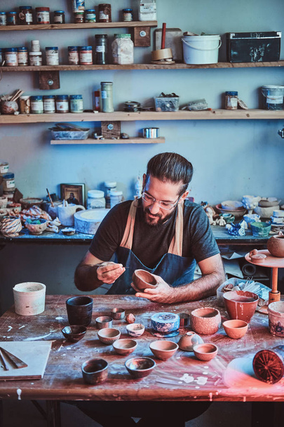 彼自身の陶芸スタジオの才能あるアーティストは、新しいプロジェクトのための仕事です. - 写真・画像