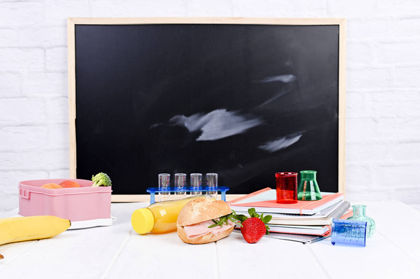 Σχολικό γεύμα στο τραπέζι και ένας πίνακας για μάθημα. Παιδί - Φωτογραφία, εικόνα