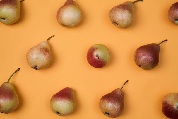 Ripe juicy pears placed on orange background. Colorful fruit pattern or background. - Fotoğraf, Görsel