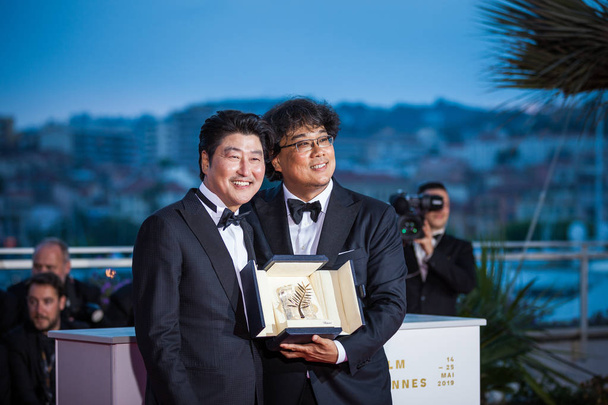 CANNES, FRANCE - MAY 25, 2019: Director Bong Joon-Ho with Kang-Ho Song, winner of the Palme d'Or award for his film "Parasite" poses at the photocall for Palme D'Or Winner during the 72nd annual Cannes Film Festival - Fotó, kép