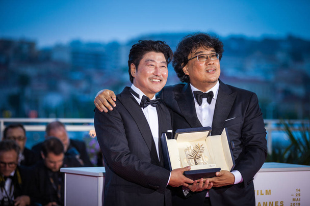 CANNES, FRANCE - MAY 25, 2019: Director Bong Joon-Ho with Kang-Ho Song, winner of the Palme d'Or award for his film "Parasite" poses at the photocall for Palme D'Or Winner during the 72nd annual Cannes Film Festival - Fotó, kép