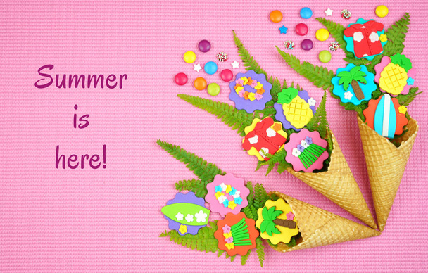 Summertime concept with ice cream cones filled with fruit, flowers and candy. - Foto, Bild