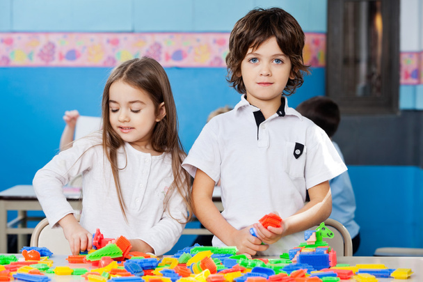 menino com fêmea amigo jogar blocos no sala de aula
 - Foto, Imagem