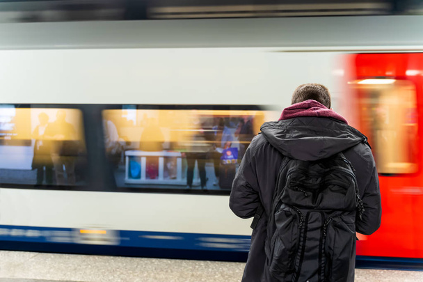 Un homme attend un train dans la station de métro, flou de mouvement
 - Photo, image