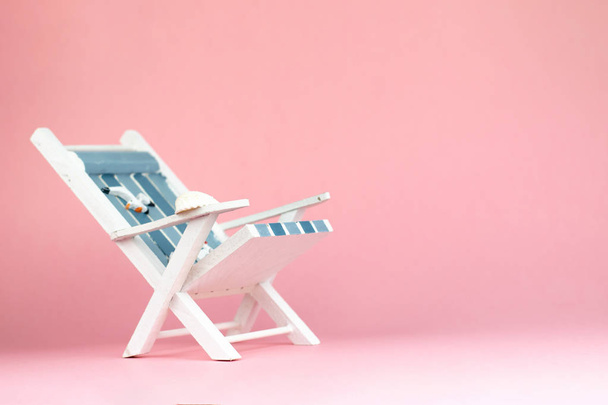 Ligstoel geïsoleerd op roze achtergrond. Tropische vakantie achtergrond. Ligstoel op het zandeiland, kopieer ruimte, vooraanzicht - Foto, afbeelding
