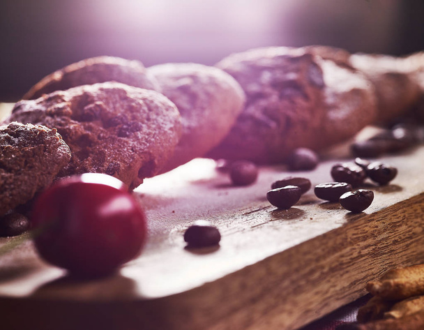 Oatmeal chocolate cookies with coffee grains and cherry. Sun flare - 写真・画像