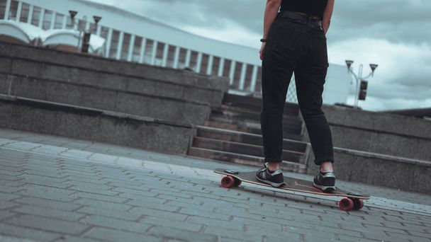 Woman skateboarder legs skateboarding at city - Foto, imagen