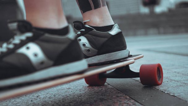 Woman skateboarder legs skateboarding at city - Фото, изображение