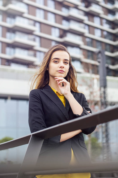 Portrait of young businesswoman standing outdoor in front of company building - Foto, Imagem