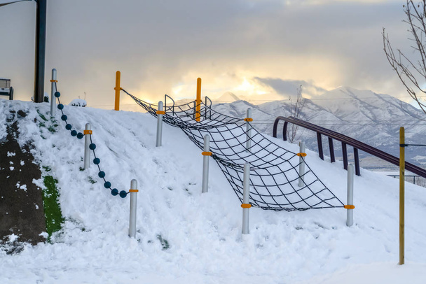 Red de escalada en un parque infantil nevado en Utah
 - Foto, Imagen