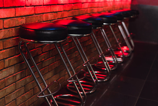 neon ışıkta tezgahta bar tabureleri. gece kulübünde barda deri sandalyeler - Fotoğraf, Görsel