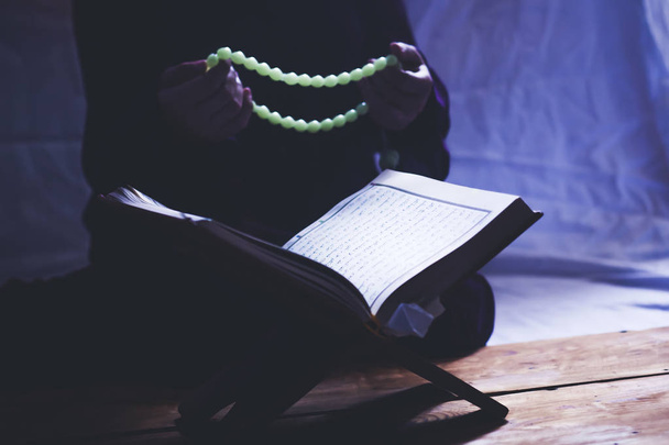 Dua eden genç müslüman kadın. Orta doğulu kız dua ediyor ve Kur'an-ı Kerim okuyor. Kuran okuyan Müslüman kadın - Fotoğraf, Görsel