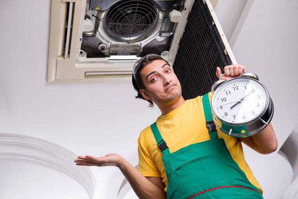 Mladý opravář opravuje stropní klimatizační jednotku  - Fotografie, Obrázek