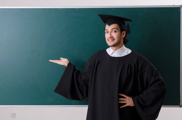 Estudante graduado na frente do quadro verde
  - Foto, Imagem