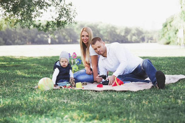 happy family sitting on the grass in the Park - Foto, imagen