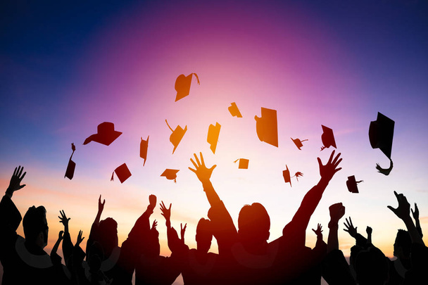 estudiantes felices lanzando gorras de graduación en el aire
 - Foto, Imagen
