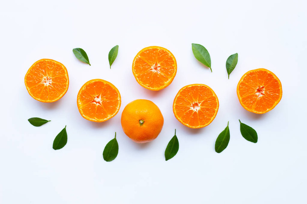 frische orange Zitrusfrüchte mit grünen Blättern auf weißem Grund. - Foto, Bild