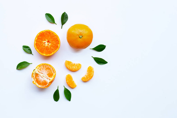 Orange fruits and green leaves on a white background.  - Foto, afbeelding