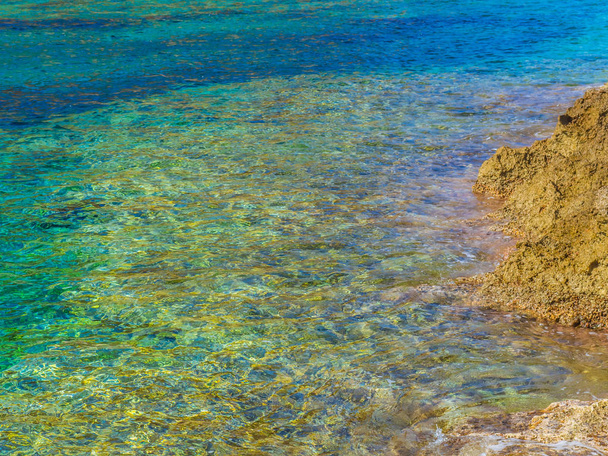 Szép azúrkék tiszta víz és a sárga sziklás part - Fotó, kép