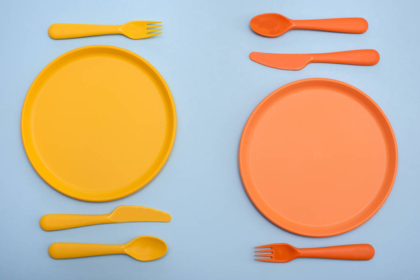 Conjuntos de comedor de colores amarillo y naranja sobre fondo azul
 - Foto, Imagen