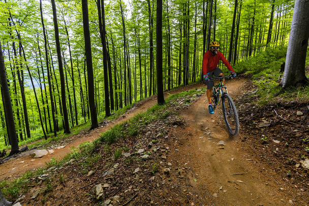 Ciclismo hombre montar en bicicleta al atardecer montañas bosque paisaje
. - Foto, imagen