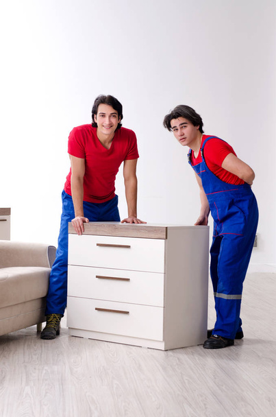 Twee jonge aannemers verplaatsen persoonlijke bezittingen  - Foto, afbeelding