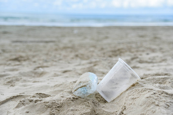 Basura en el mar con botella de plástico, taza de plástico y espuma bo
 - Foto, imagen