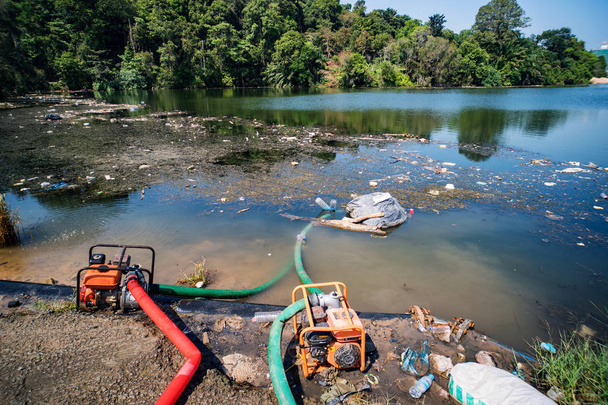 Dépôt municipal dans l'étang de Park. Les ordures se trouvent dans l'eau sur l'un des paysages urbains. bouteilles en plastique ont été jetées dans l'eau. tuyaux dans l'eau
. - Photo, image