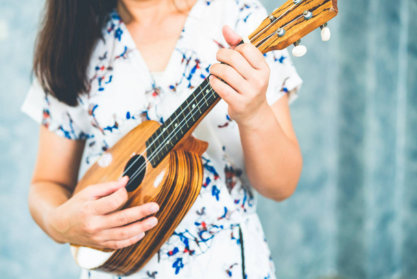 Happy woman musician playing ukulele in studio. - Photo, Image