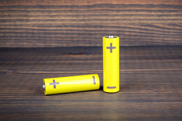 AA rozměry baterie na dřevěné pozadí - Fotografie, Obrázek