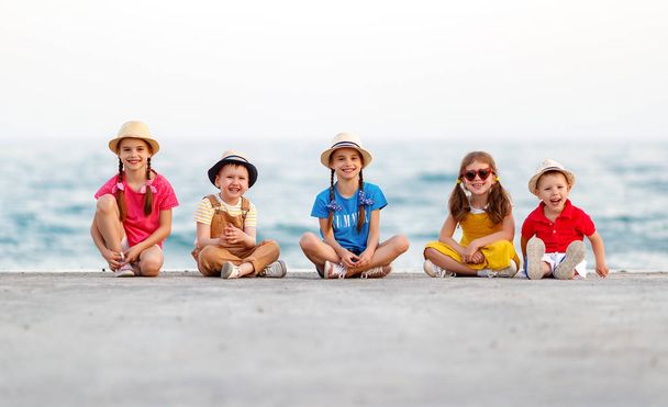 group of happy children by   sea in summe - Foto, afbeelding