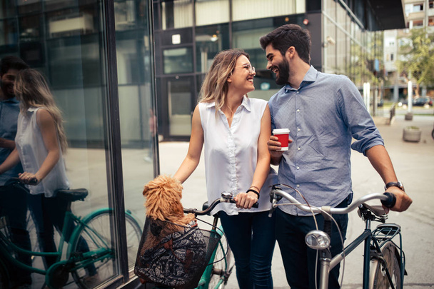 Attractive woman and handsome man spending time together with dog and bicycles - Фото, зображення