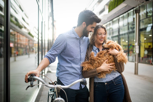 Attractive woman and handsome man spending time together with dog and bicycles - Photo, image