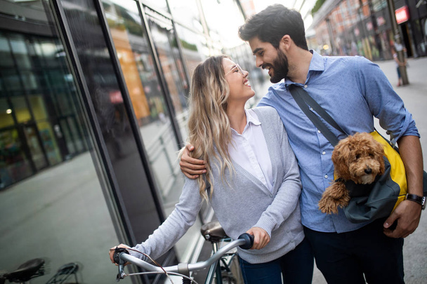 Happy couple in love with dog walking and smiling outdoor - Foto, Imagen