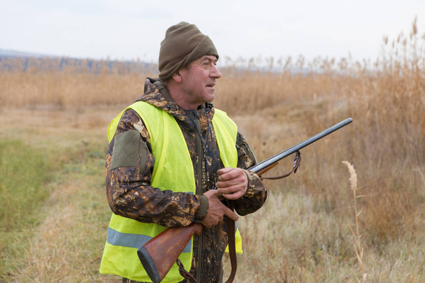 Male hunter with shotgun hunting outdoors - Fotó, kép
