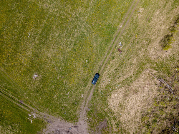 Vista aérea de un coche negro de pie en un campo en medio de
  - Foto, Imagen