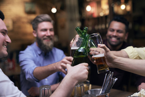 Grupo de homens fazendo um brinde para um bom fim de semana
 - Foto, Imagem