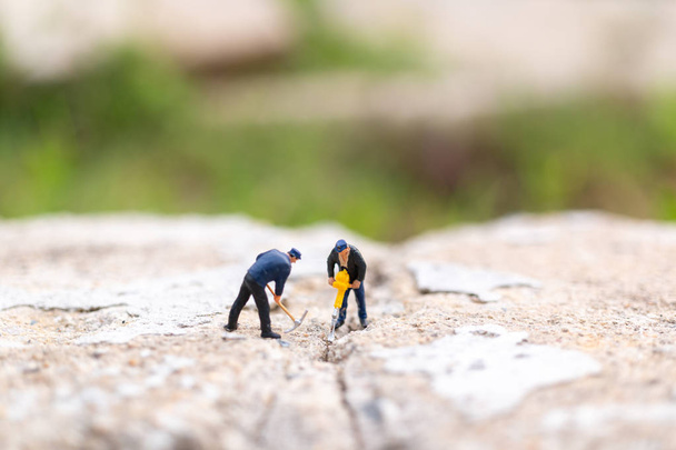 Miniature people : Worker team working on  concrete with cracked - Photo, Image
